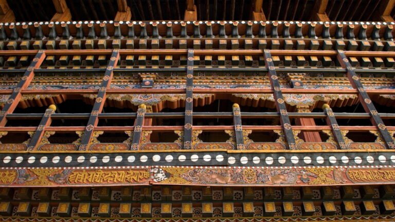 Hand-painted carved wooden windows on a traditional Bhutanese building
