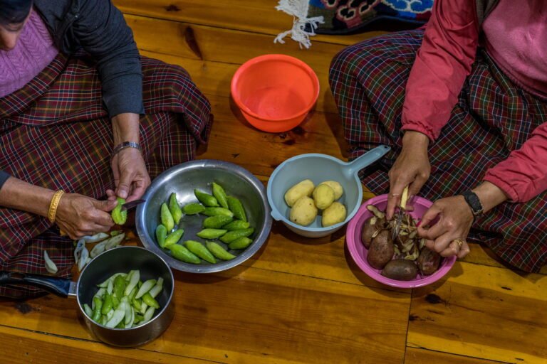 Women preparing vegetables for a home-cooked meal in Haa, Bhutan
