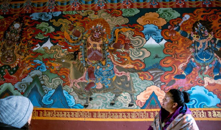 Traveller looking at a painted Buddhist mural in Bhutan